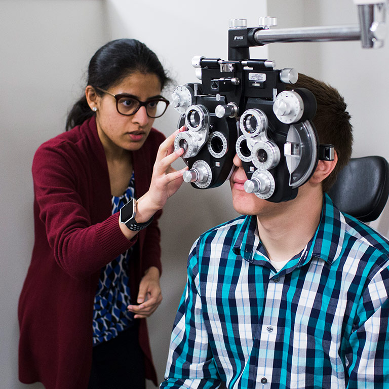 Optometry students practice giving eye exams.