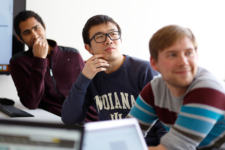 Three male students in a classroom setting