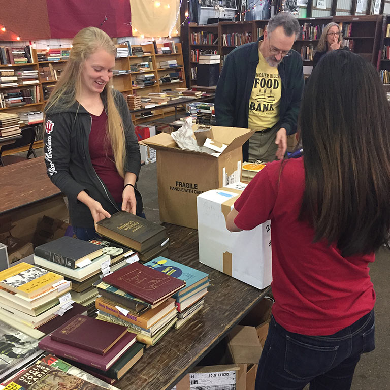 Optometry students in the Honor Society pack boxes with books.