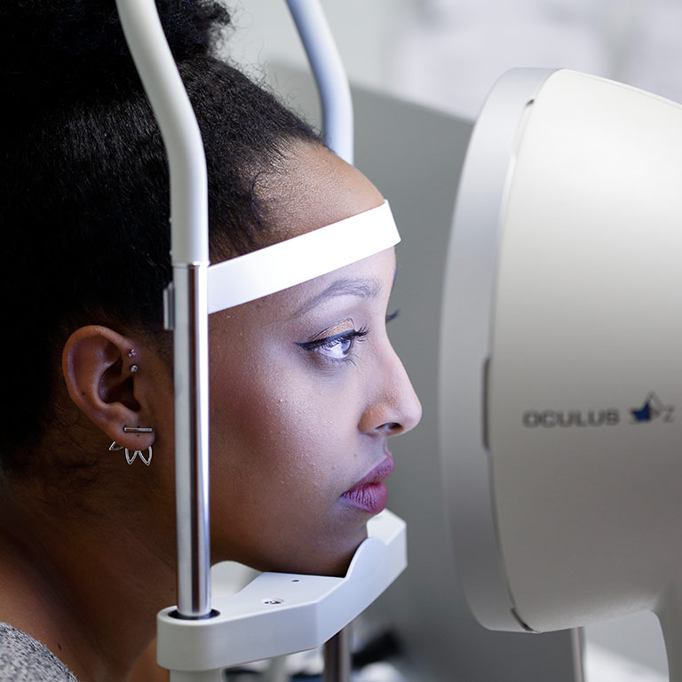 A woman stares into an Oculus Rift, a virtual reality headset and position tracking system.